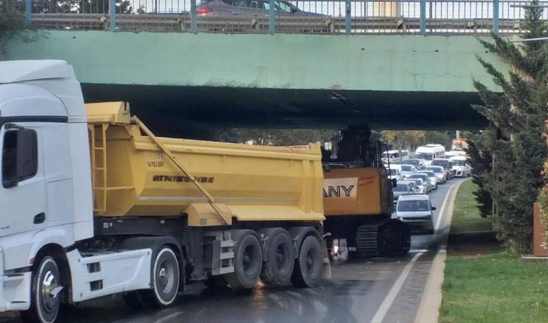 Kartal'da dorsesinde iş makinesi taşıyan tırın köprü altında sıkışması trafik