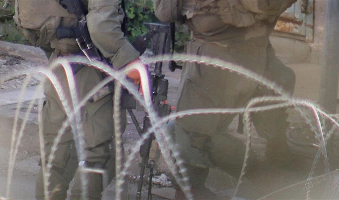 Yüzü maskeli, askeri üniformalı ve silahlı kişiler, Gazze'de alıkonulan Filistinliye