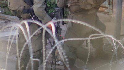 Yüzü maskeli, askeri üniformalı ve silahlı kişiler, Gazze'de alıkonulan Filistinliye