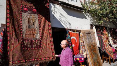 Halı ve kilim dokumacısı Ahmet Geyiklioğlu, üzerinde Taksim Cumhuriyet Anıtı,